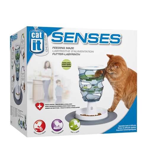 Cat using interactive feeding maze toy next to product box for cat health and wellbeing.